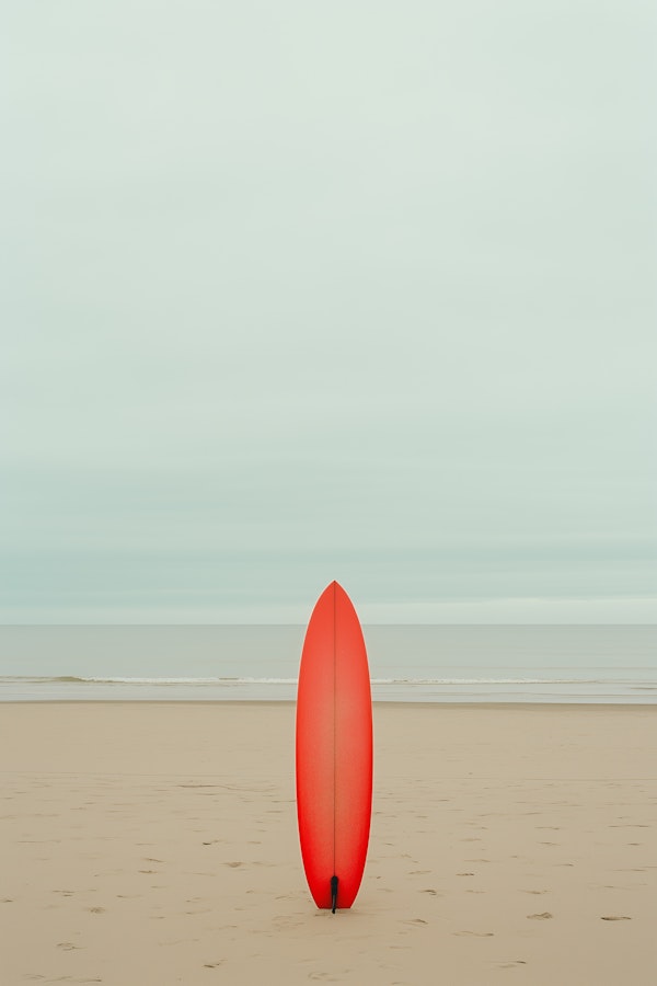 Serene Beach and Red Surfboard