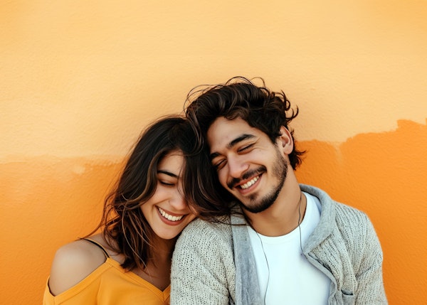 Joyful Young Couple Against Orange Wall