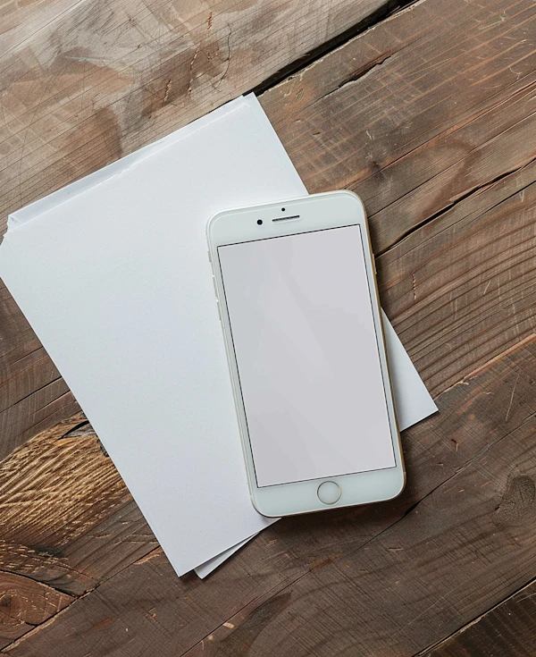 Smartphone and Papers on Wooden Desk