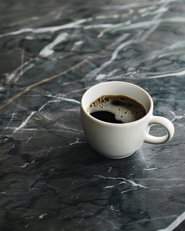 Frothy Coffee in White Cup on Marble Surface