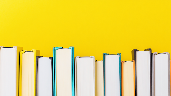 Colorful Books Against Yellow Background