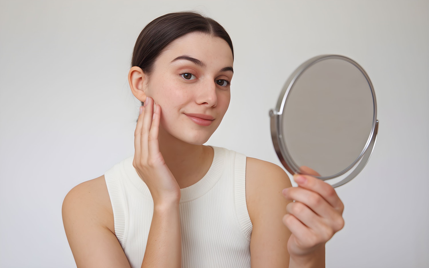 Young Woman Examining Face in Mirror