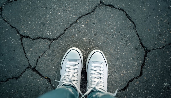 Urban Exploration - Gray Canvas Sneakers on Cracked Asphalt