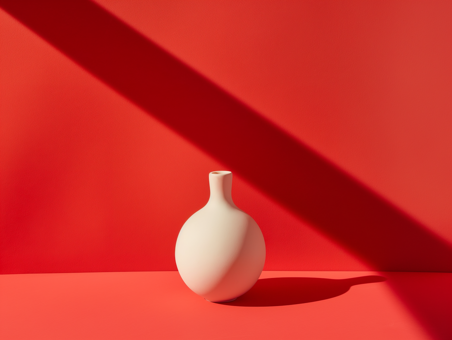 Minimalist White Vase Against Red Background