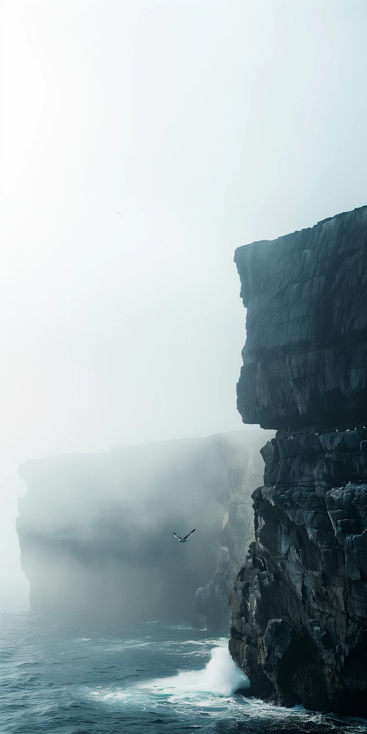 Majestic cliffs rising from a misty ocean with a bird soaring nearby