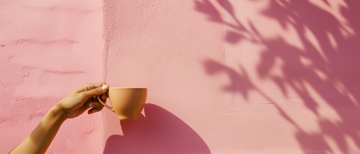 Coffee Cup in Hand Against Pink Wall with Shadowed Palm Leaves