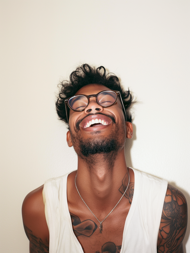 Smiling Man with Tattoos and Glasses