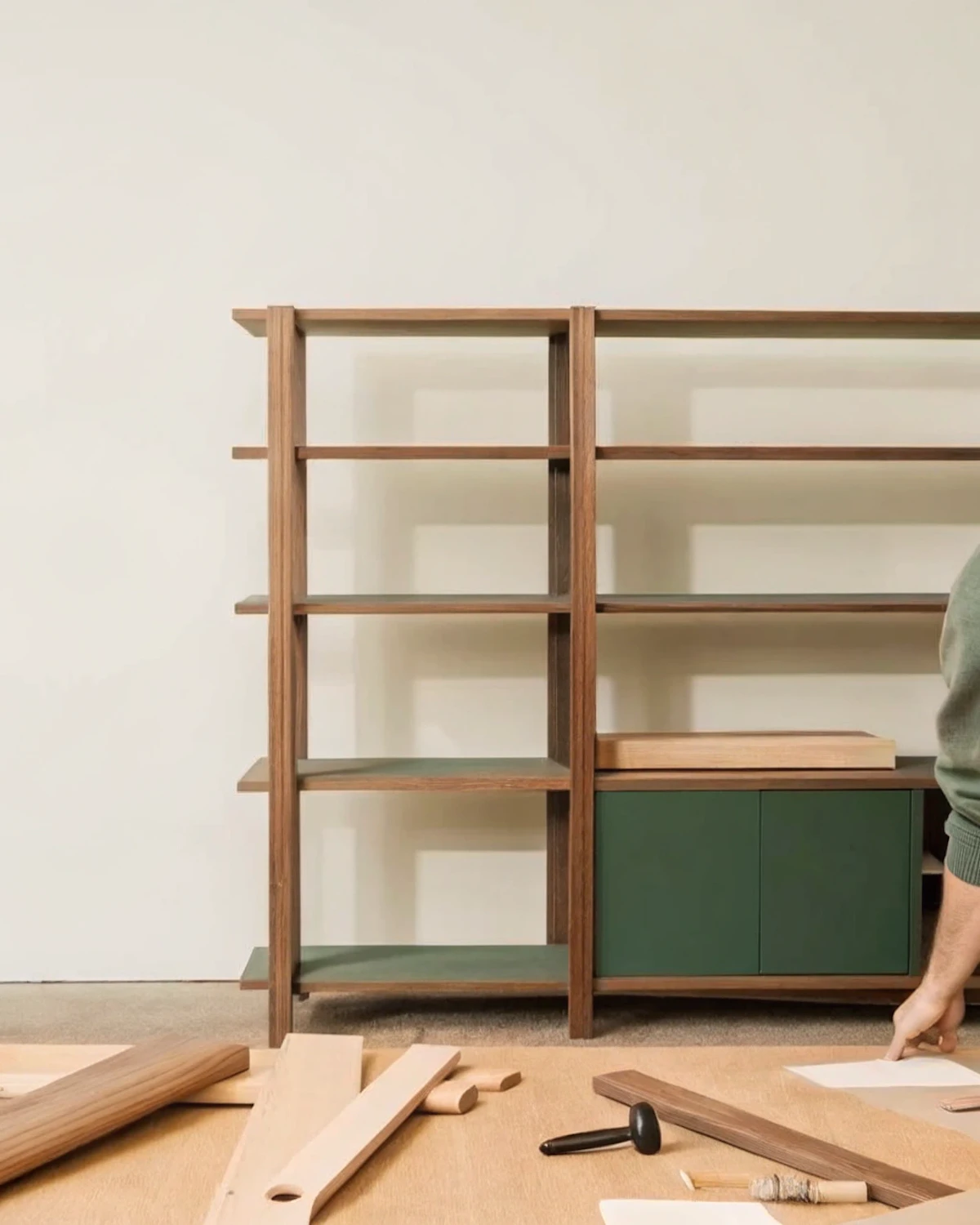 A part-built wooden shelving unit surrounded by tools and loose planks