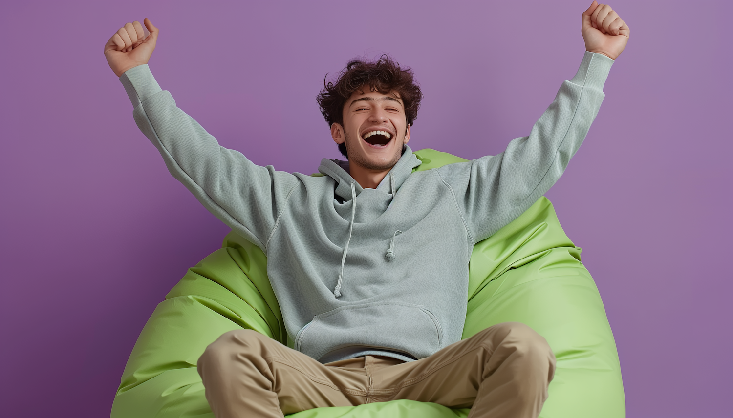 Exuberant Young Man on Green Beanbag Chair