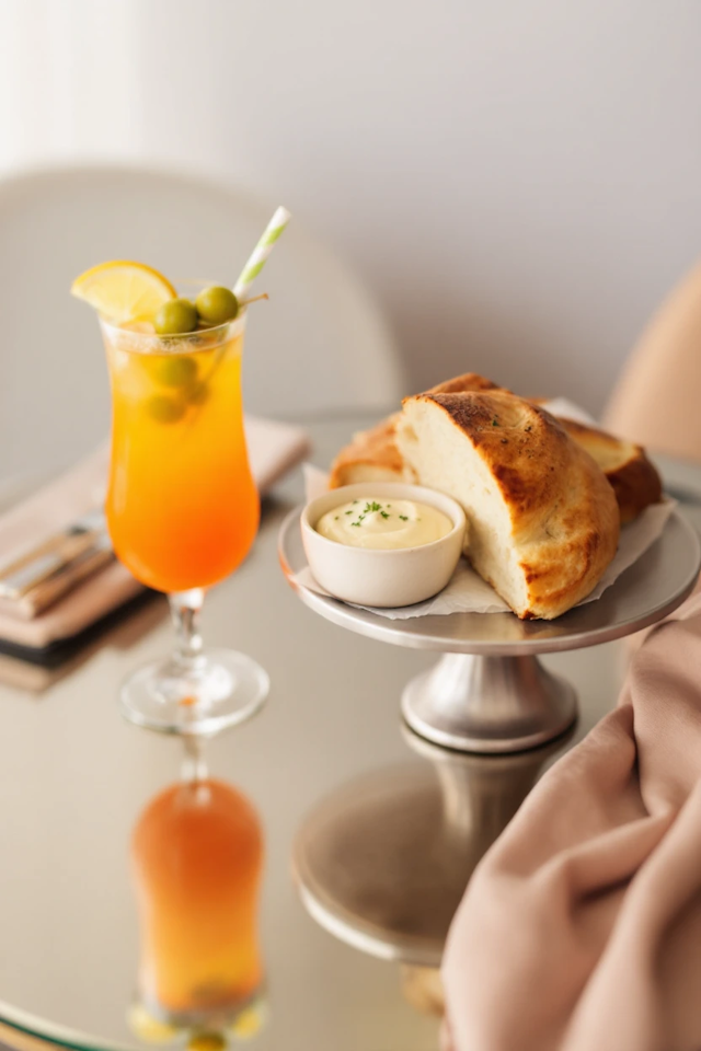 Cocktail and Bread on Reflective Surface