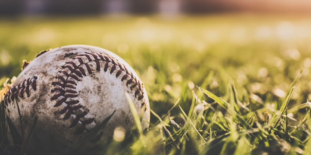 Close-up of a Well-Worn Baseball on Grass