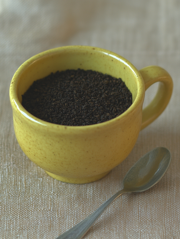 Yellow Ceramic Cup with Black Tea Leaves