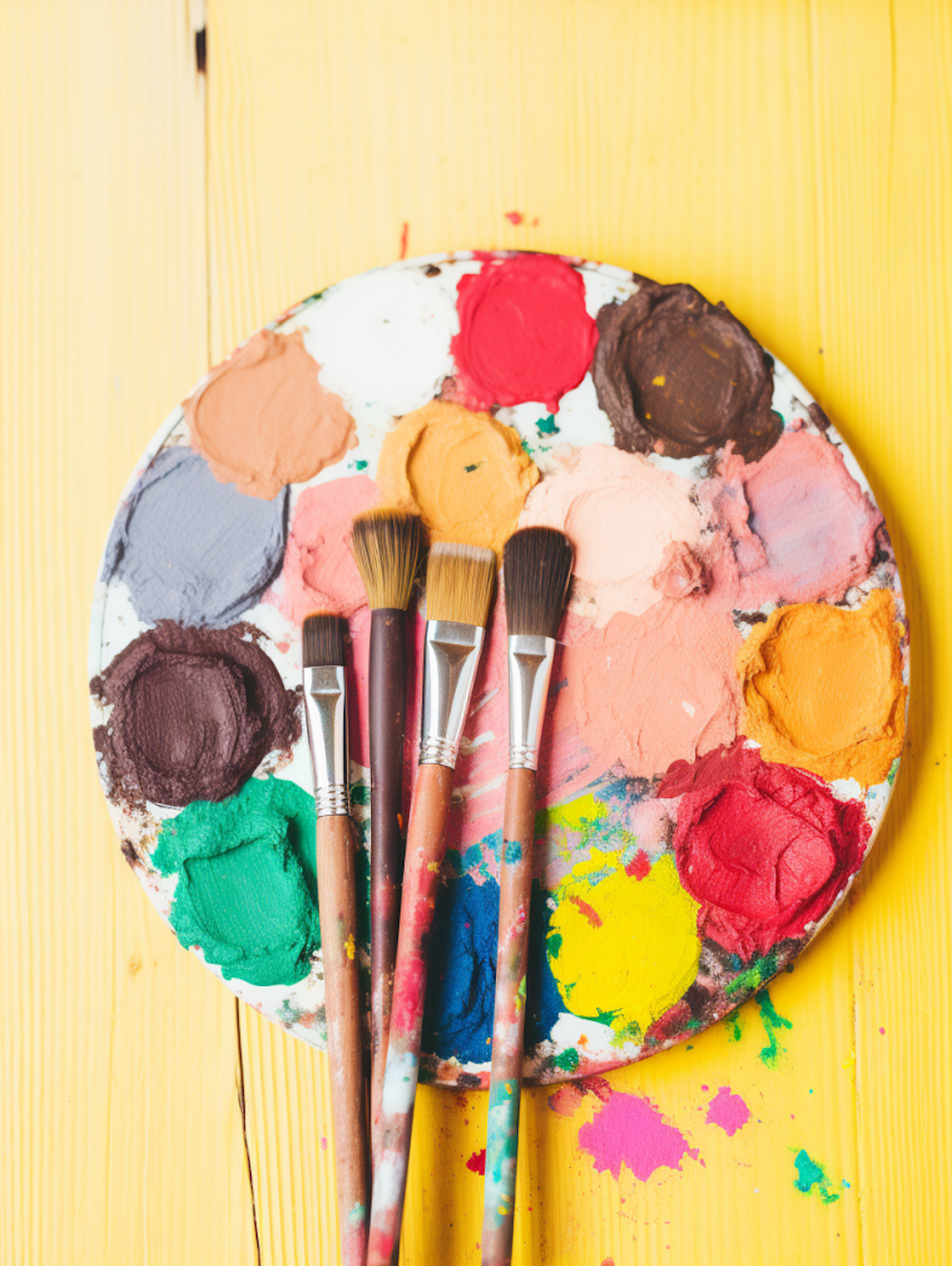 Artistic Palette with Paintbrushes on Yellow