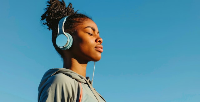 Person with Headphones Against Blue Sky