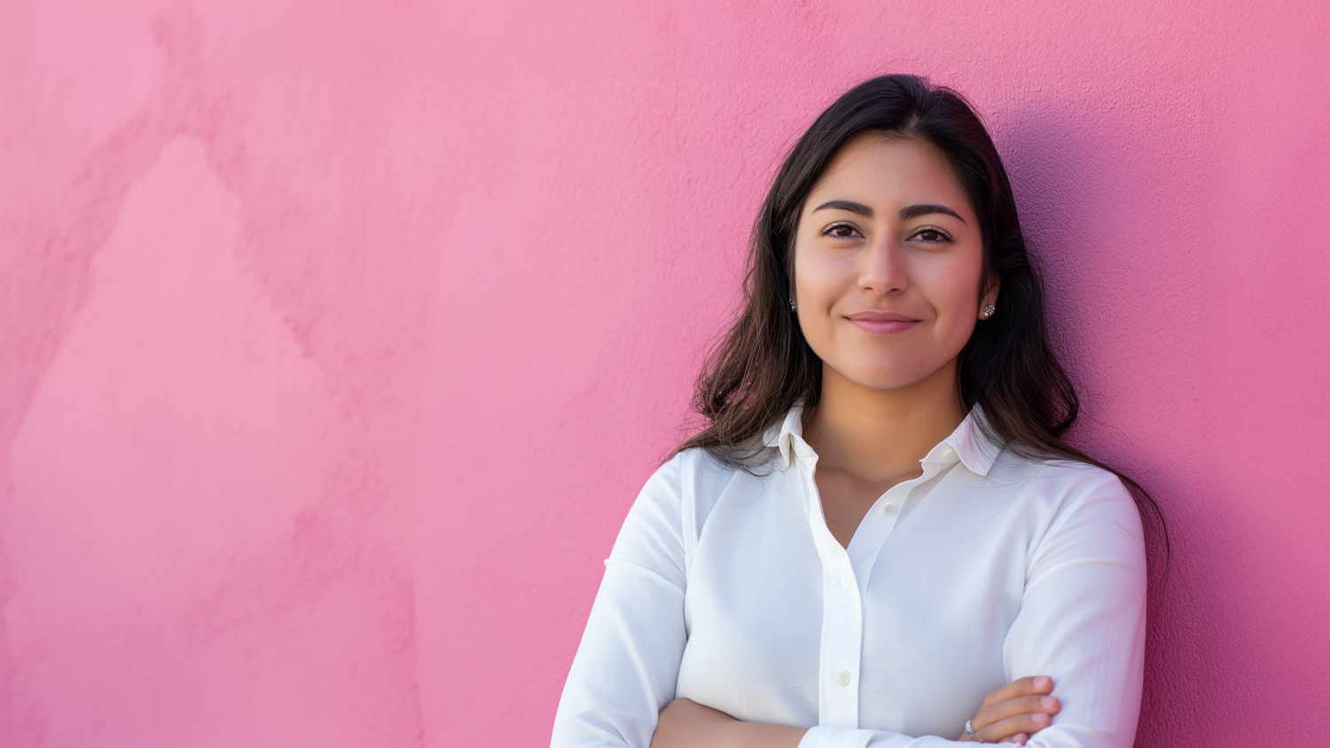 Confident Latina Woman in White Shirt Against Pink Background