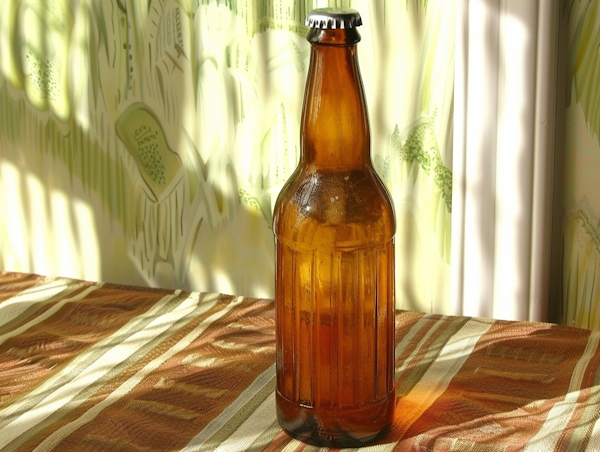 Warmly Lit Glass Bottle on Striped Fabric