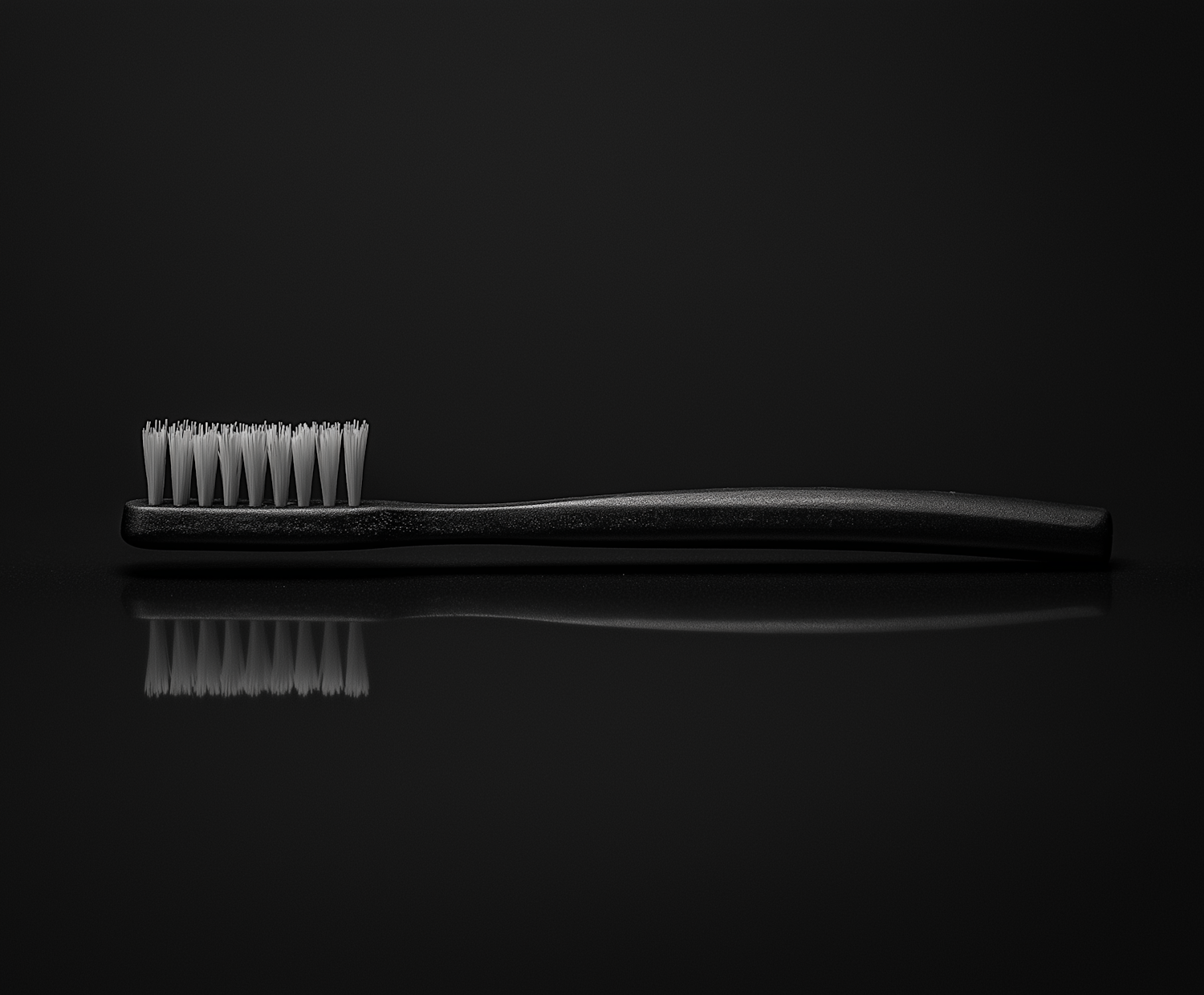 Worn Black Toothbrush on Reflective Surface