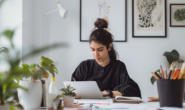 Young Woman Working on Laptop in Home Office