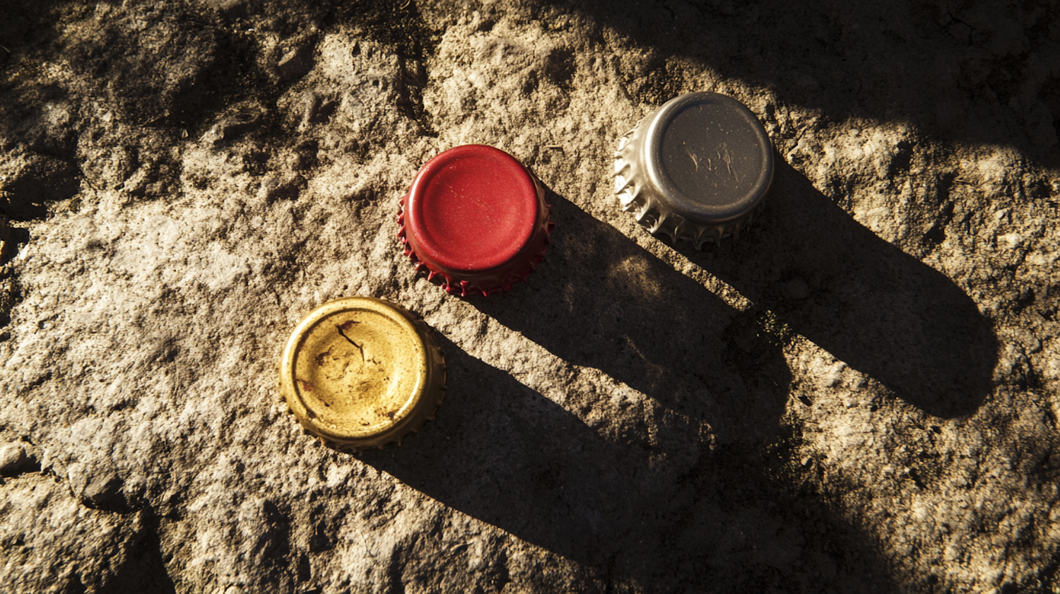 Bottle Caps on Rocky Surface