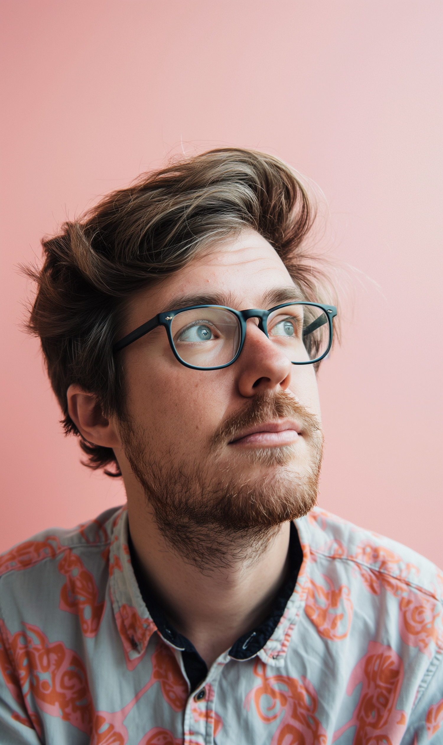 Thoughtful Young Man with Glasses and Patterned Shirt