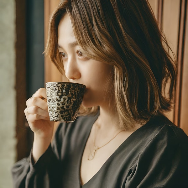 Serene Woman Sipping coffee from Ornate Ceramic Cup