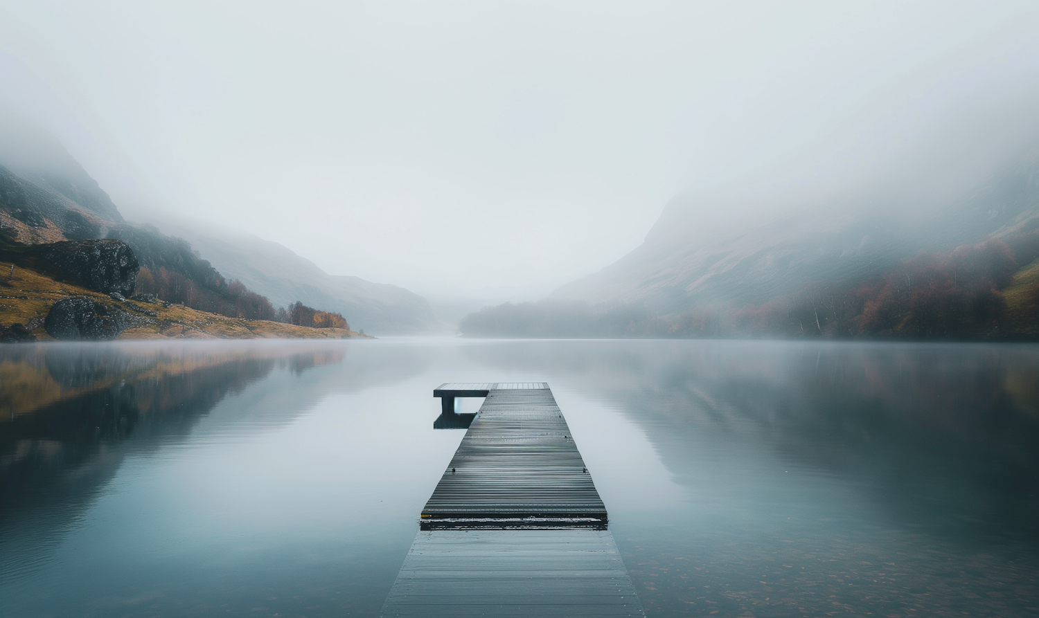 Serene Lake with Misty Mountains and Wooden Pier