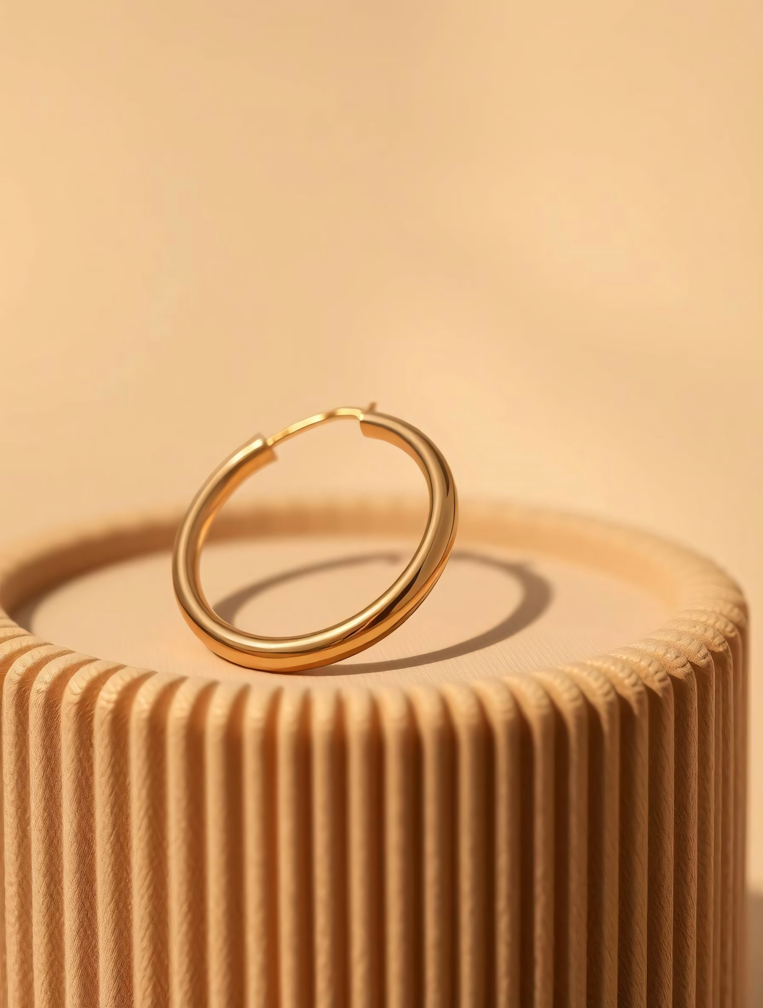 Gold Hoop Earring on Textured Pedestal