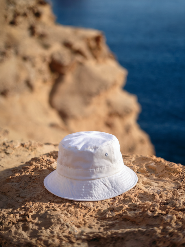 White Bucket Hat on Rocky Surface