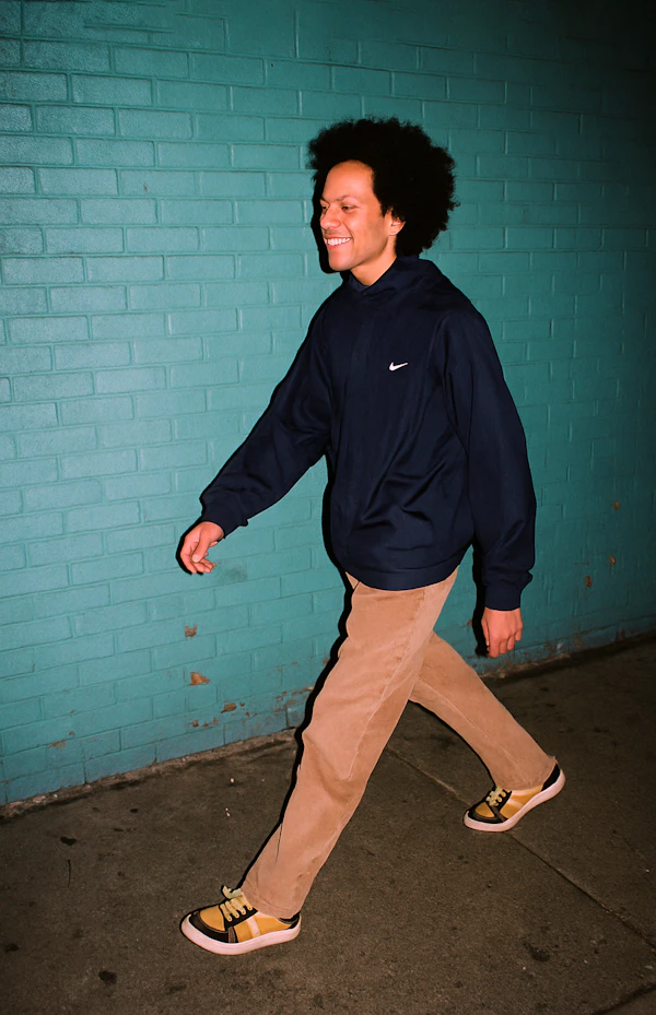 Man Walking by Teal Wall