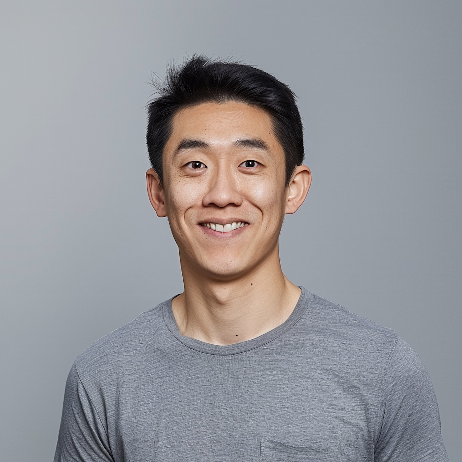 Young Man Smiling Against Gray Background