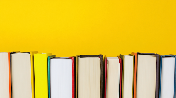 Colorful Books Against Yellow Background