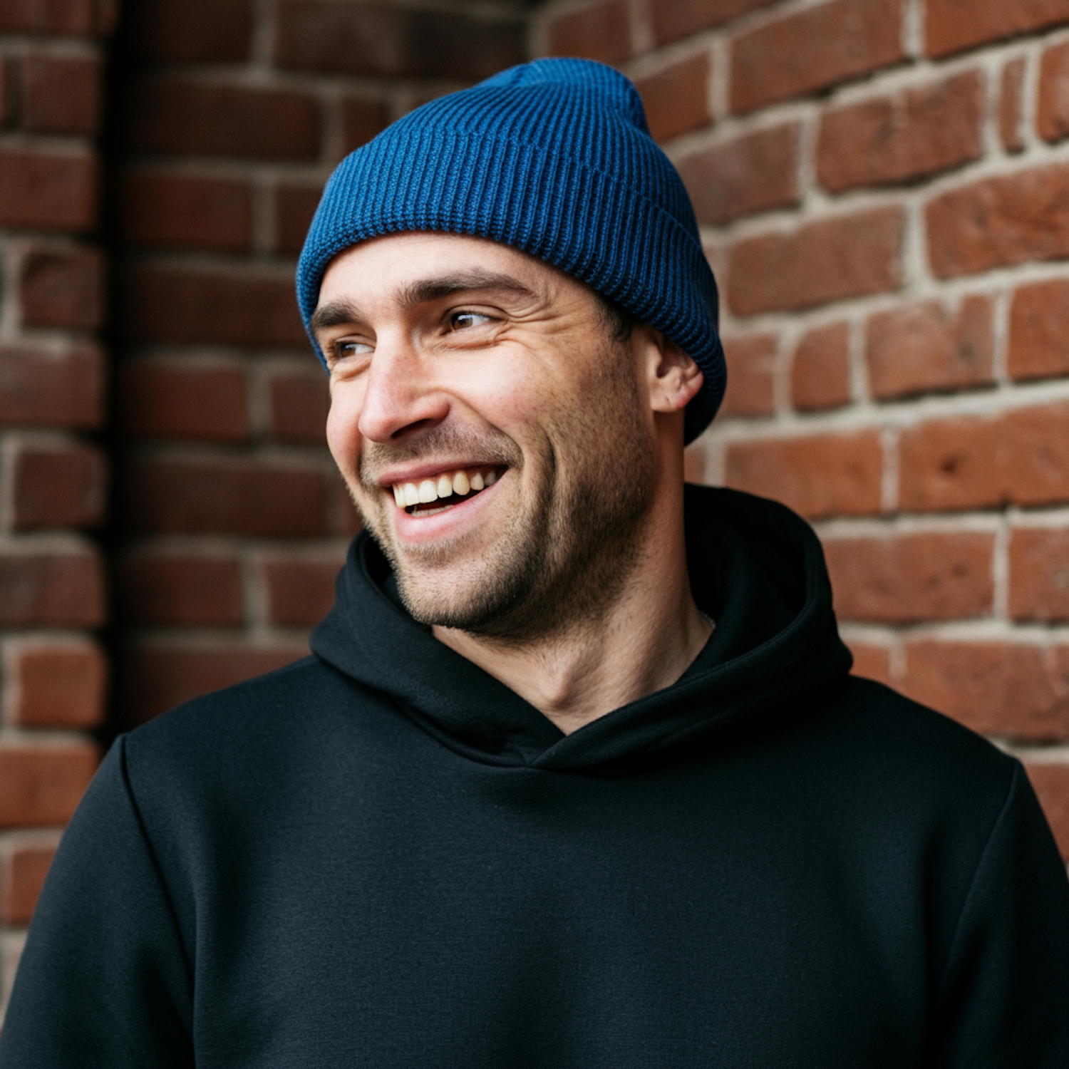 Man in Blue Beanie Against Brick Wall