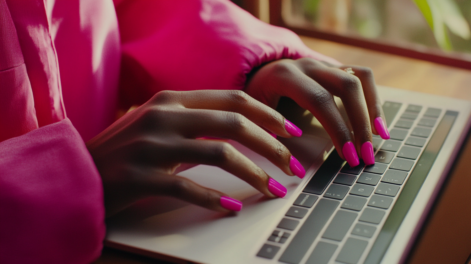 Hands Typing on Laptop with Pink Nails